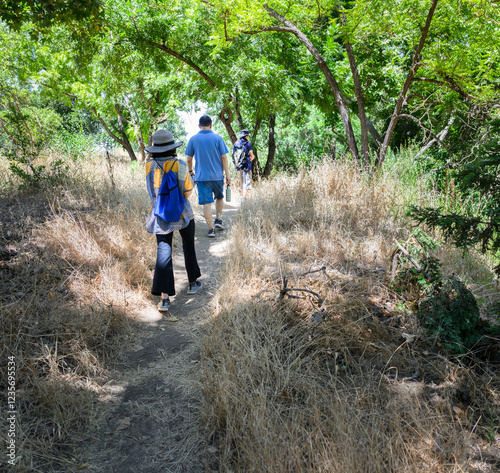 Obraz na płótnie A group of friends walking in the bush. Dried grass along the path. California. w salonie