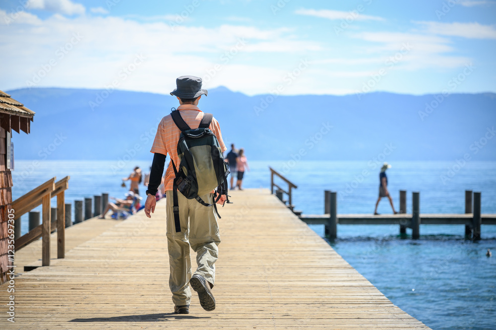 Man walking on the jetty at Ed Z’berg Sugar Pine Point State Park. Lake Tahoe. California.