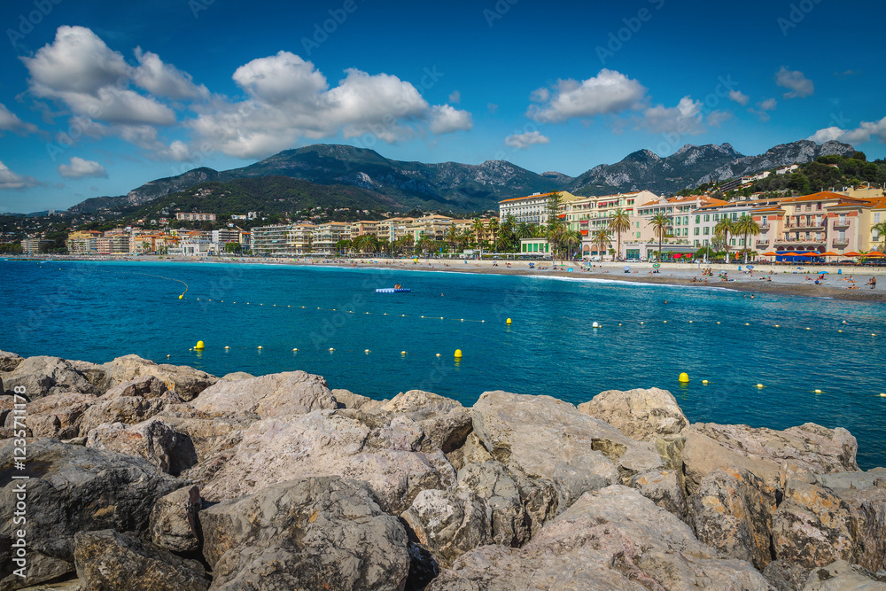 Seaside buildings with promenade and beautiful beach of Menton, France