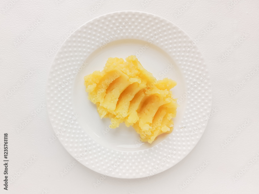 Mashed potatoes in a white plate on the table, top view. The second course. Garnish. Potato starch. Mashed potatoes in a white plate on the table, top view. The second course. Garnish. Potato starch.