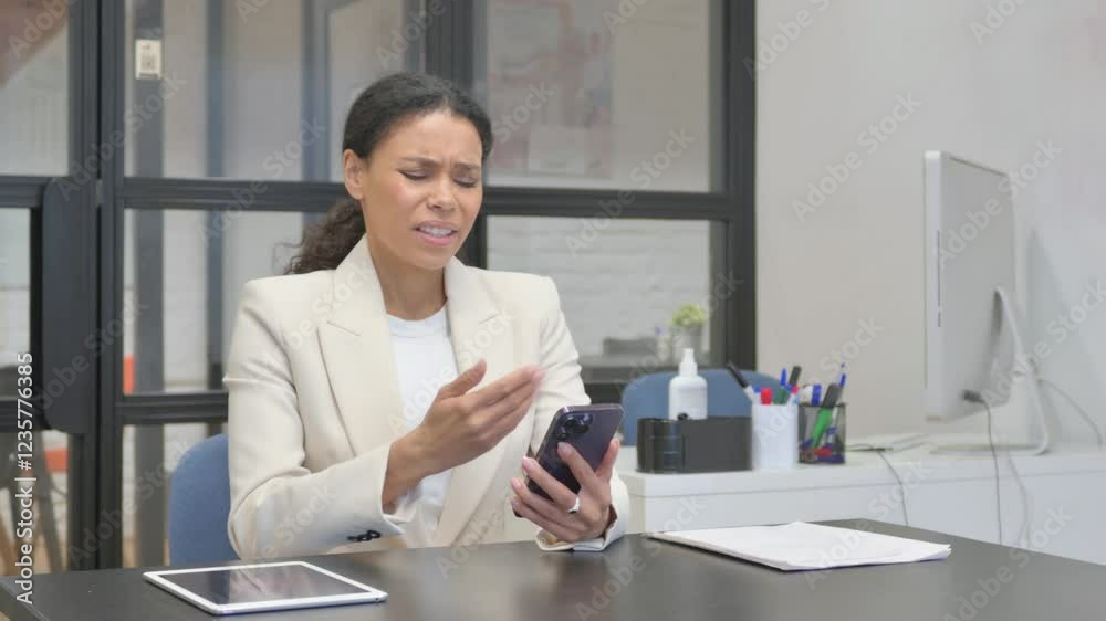 African Business Woman Shocked by Loss on Phone in Office African Business Woman Shocked by Loss on Phone in Office