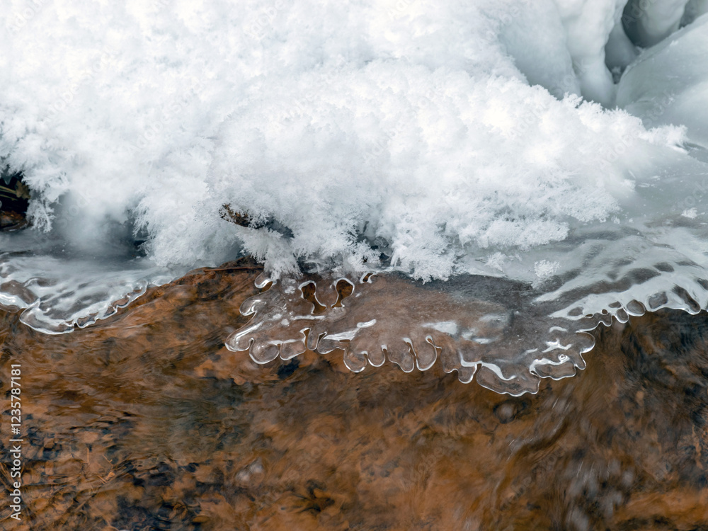Obraz premium winter photography with ice, water and sandstone rocks, ice icicles, running water