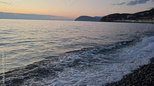 Colorful ocean beach sunrise with deep blue sky and sun.