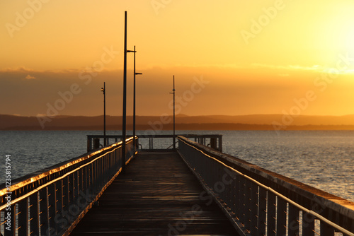 Wellington Point pier extending into a calm ocean at sunset