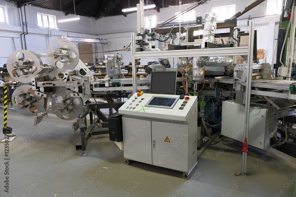 A complex machine stands in a factory hall