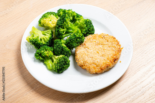 Wallpaper Mural Fresh green broccoli sits beside a golden, crispy patty, creating a vibrant and nutritious meal. This appetizing dish invites a healthy lifestyle, perfect for any time of day.  Torontodigital.ca