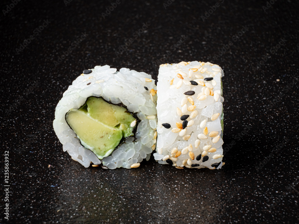 Two beautifully made sushi rolls display creamy avocado nestled in soft rice, adorned with sesame seeds. The contrasting colors create an inviting, appetizing scene perfect for food lovers. Two beautifully made sushi rolls display creamy avocado nestled in soft rice, adorned with sesame seeds. The contrasting colors create an inviting, appetizing scene perfect for food lovers.