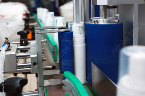 Tablou pe pânză White plastic bottle is moving along conveyor belt