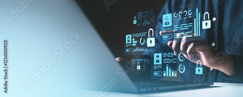 Digital security concept with a man interacting with holographic locks and data icons on a laptop screen. photo
