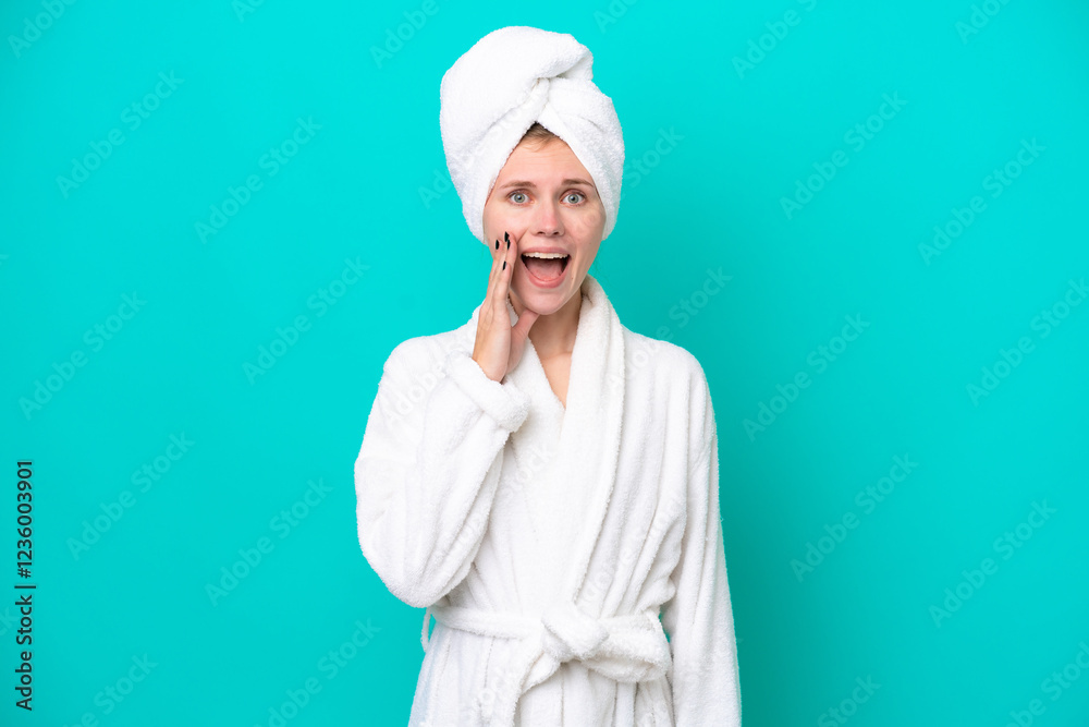 Young woman in a bathrobe isolated on blue background with surprise and shocked facial expression Young woman in a bathrobe isolated on blue background with surprise and shocked facial expression