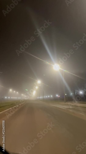 foggy empty city road night view from inside car path forward into the unknown