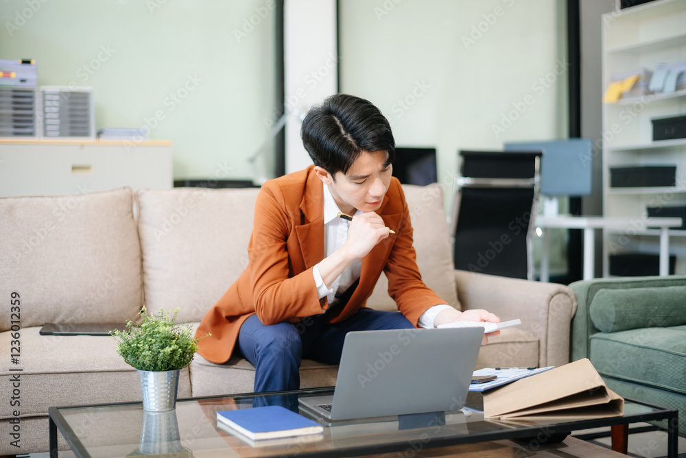 Confident entrepreneur multitasking with a laptop and phone in a modern office. Perfect for business, remote work, finance Confident entrepreneur multitasking with a laptop and phone in a modern office. Perfect for business, remote work, finance