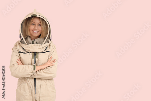 Female beekeeper on pink background photo