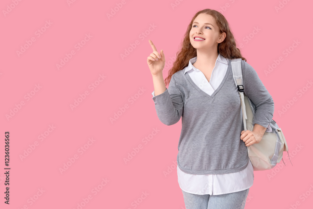 Happy female student with backpack pointing at something on pink background Happy female student with backpack pointing at something on pink background