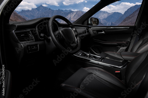 A black car with a steering wheel and a mountain in the background