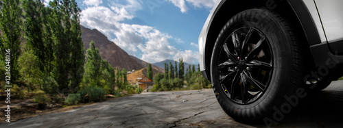 A black tire on a road with a mountain in the background