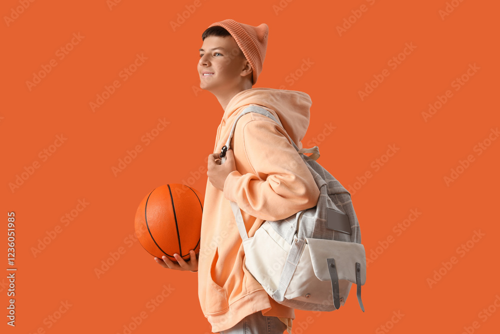 Teenage boy with ball on orange background Teenage boy with ball on orange background