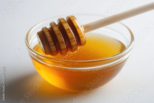 A bowl filled with honey, featuring a wooden stick inserted into the contents