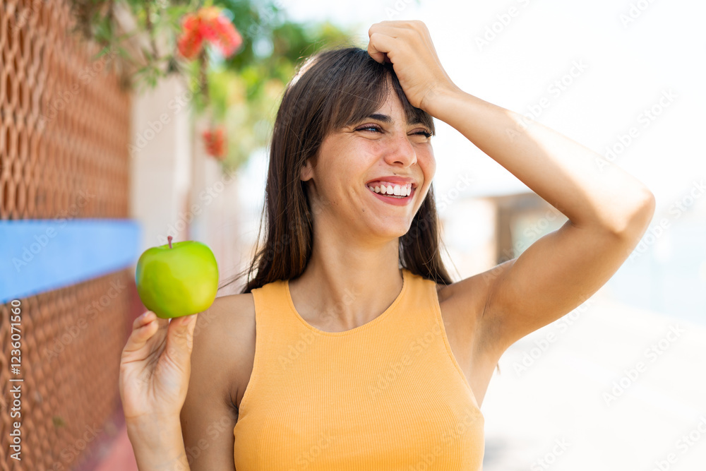 Young woman with an apple at outdoors has realized something and intending the solution Young woman with an apple at outdoors has realized something and intending the solution