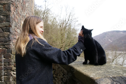 Girl young petting a black cat