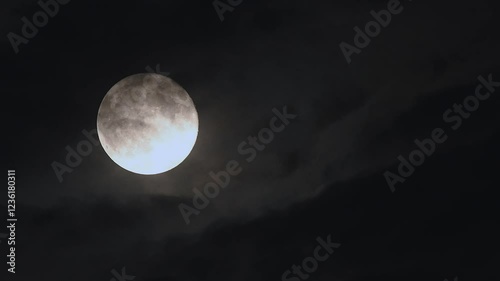 Experience the full moon rise through drifting clouds in stunning 4k time lapse on a dark night sky