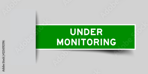Green color square label sticker with word under monitoring that inserted in gray background