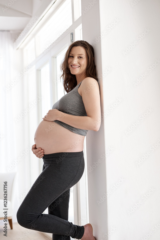 Happy woman, confident or pregnancy in home with portrait, growth or baby bump for development. Smile, touch stomach or pregnant with maternity wellness to relax for security, belly or motherhood Happy woman, confident or pregnancy in home with portrait, growth or baby bump for development. Smile, touch stomach or pregnant with maternity wellness to relax for security, belly or motherhood