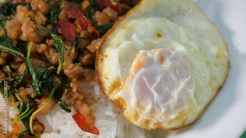 Fotografía stir fried pork with holy basil on top with fried egg on cooked rice