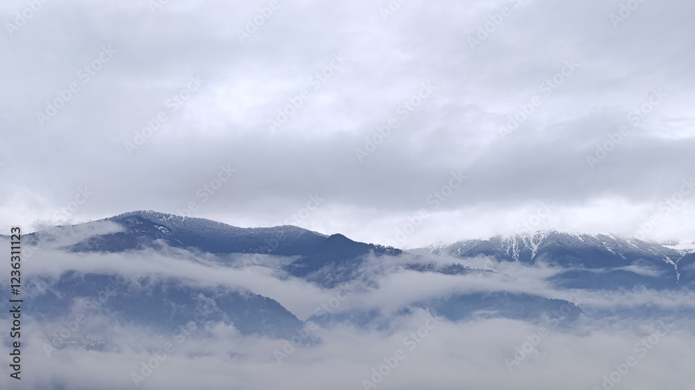 Mountain peaks in the clouds. Heavy fog in the mountains. Cloudy weather. Mountain peaks in the clouds. Heavy fog in the mountains. Cloudy weather.