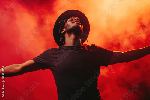 Portrait of single isolated young african hipster guy dancing in trendy hat and black t-shirt in nightclub over red smoky background