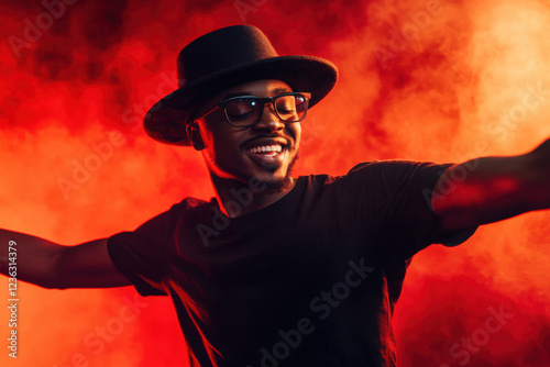 Portrait of single isolated young african hipster guy dancing in trendy hat and black t-shirt in nightclub over red smoky background