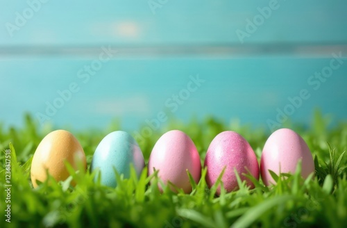 pastel-colored easter eggs in grass with wooden plank background - concept of spring festivities, colorful egg hunt, seasonal joy
