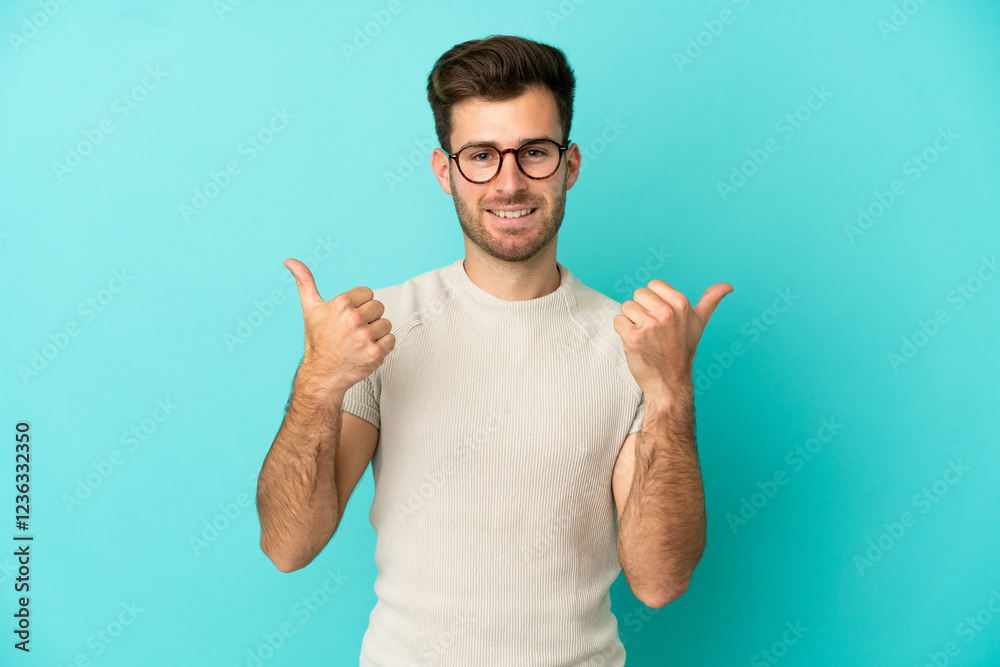 Young caucasian handsome man isolated on blue background with thumbs up gesture and smiling Young caucasian handsome man isolated on blue background with thumbs up gesture and smiling