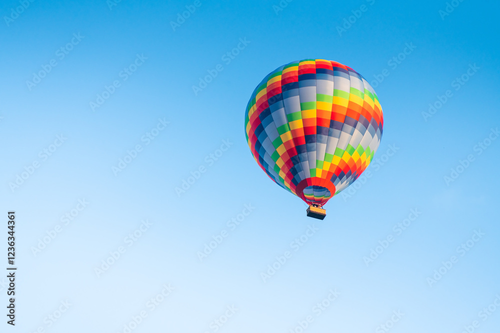 Colorful hot air balloon against the blue sky at sunny day.