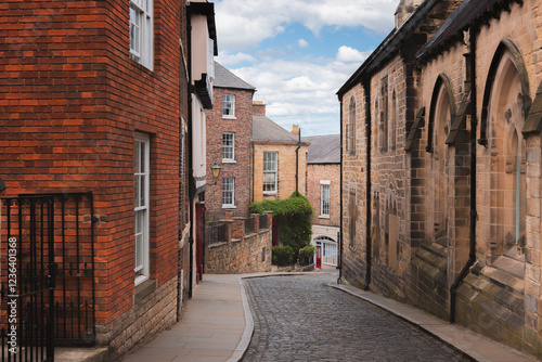 Cobblestone street winding through the historic old town of Durham, England with traditional architecture and a peaceful atmosphere.