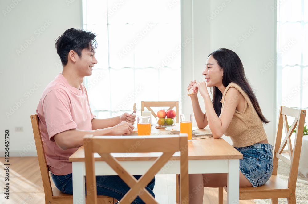 Couple Enjoys a Cheerful Breakfast at a Bright, Modern Dining Table in a Cozy Home Setting Couple Enjoys a Cheerful Breakfast at a Bright, Modern Dining Table in a Cozy Home Setting