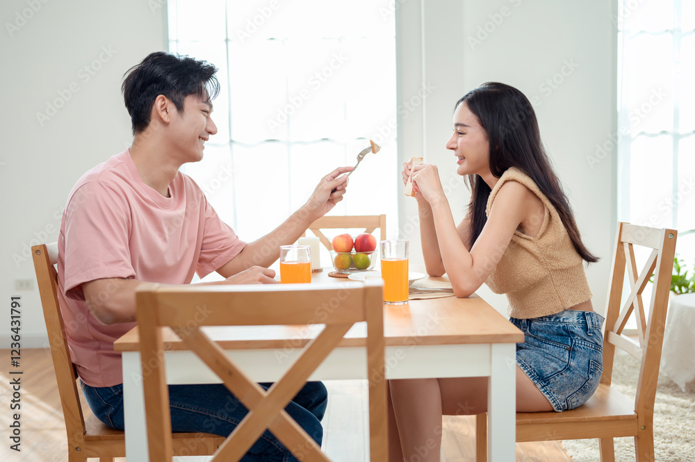 Couple Enjoys a Cheerful Breakfast at a Bright, Modern Dining Table in a Cozy Home Setting Couple Enjoys a Cheerful Breakfast at a Bright, Modern Dining Table in a Cozy Home Setting