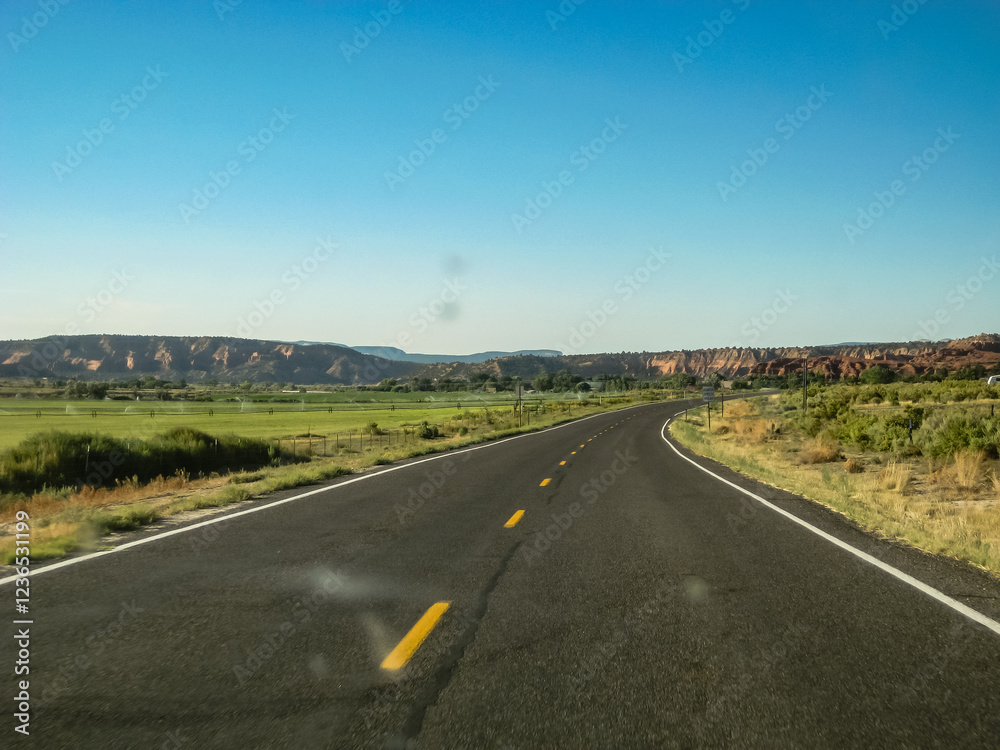 A long, empty road with a clear blue sky above A long, empty road with a clear blue sky above