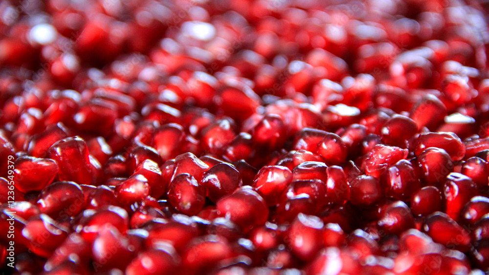 Vibrant red pomegranate seeds pop in sharp focus, with a soft blur adding depth and freshness. Ideal for natural food, fresh fruit, and healthy living projects.