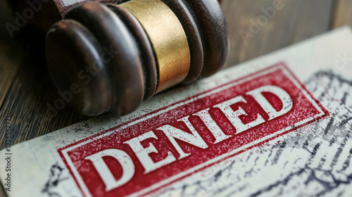 Application form showing denied stamp and gavel on table