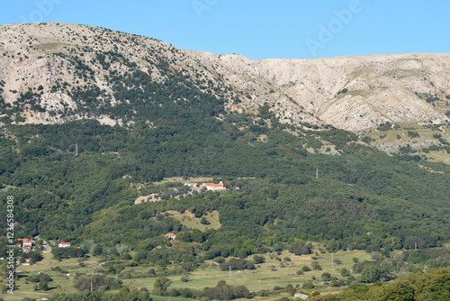 Nestled amidst a lush, verdant landscape, the Sanctuary of the Mother of God of Gorica (Svetiste Majke Bozje Goricke) stands prominently in the center of the image, on Island Krk in Croatia photo