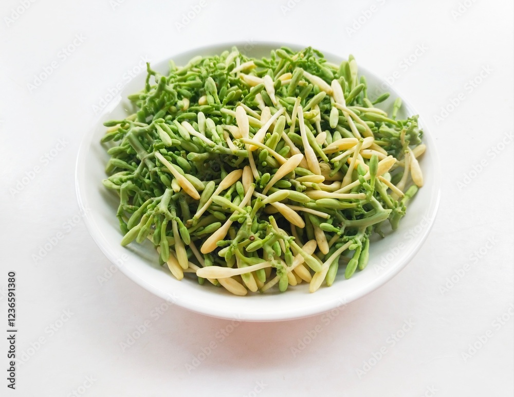 High angle view of uncooked papaya flower vegetables in a white plate on a white background. High angle view of uncooked papaya flower vegetables in a white plate on a white background.