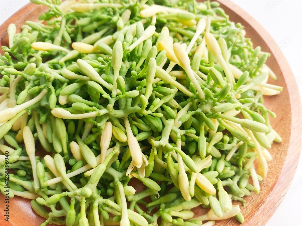 Close-up of uncooked papaya flower vegetables in wooden plate on white background. Close-up of uncooked papaya flower vegetables in wooden plate on white background.
