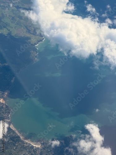 Aerial views form a plane looking through the clouds onto dramatic coastline. 