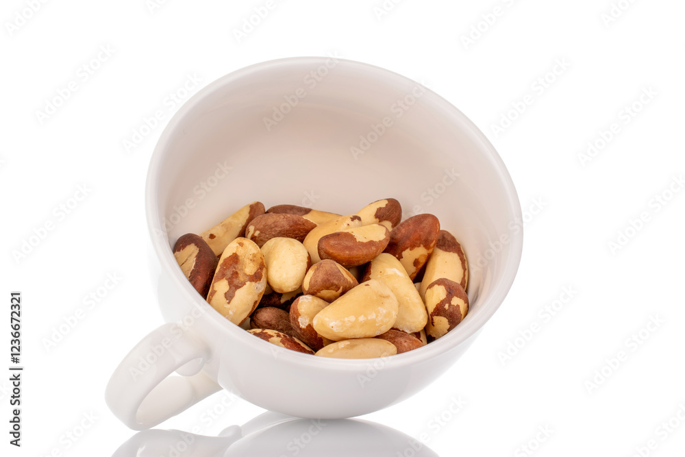 Brazil nuts without shells in a white ceramic cup, macro, isolated on a white background. Brazil nuts without shells in a white ceramic cup, macro, isolated on a white background.