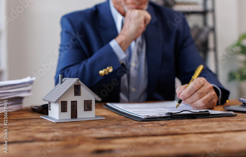 Real estate broker agent presenting and consult to customer to decision making sign insurance form agreement, buy and sell home model, concerning mortgage loan offer for and house insurance