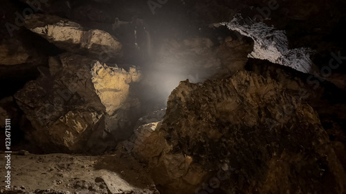 Bilde på lerret A dimly lit cave interior with rugged rock formations, evoking exploration and a
