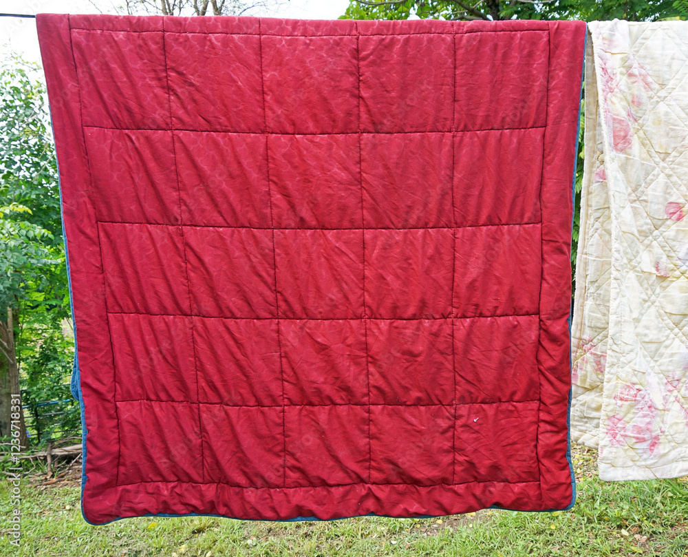 Naklejka premium red blanket hanging on a clothesline