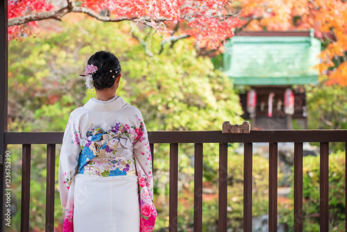 woman in Kimono view shrine and autumn colors in Shinnyodo, Kyoto photo