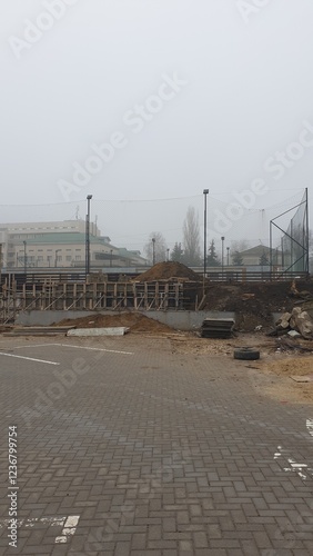 city, construction site, paving slabs, building, fog, lights, fence, construction